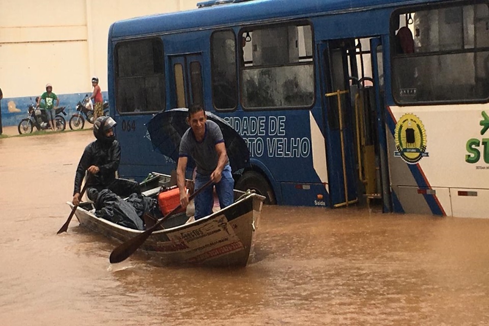 Cidadãos andam de canoa, na “região entre rios” de Porto Velho, durante temporal